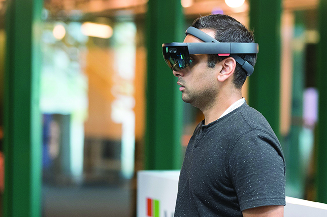 A Hack the North participant checks out a Microsoft HoloLens visor, which allows the user to interact with high-definition holograms. Photo by JK Liu.