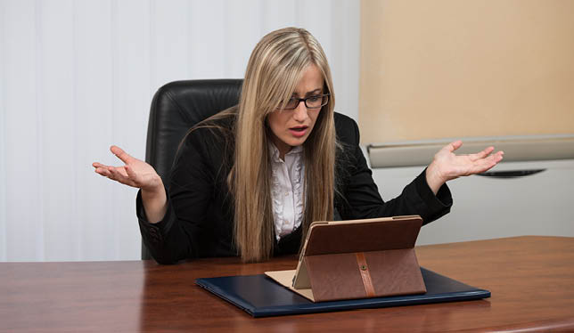 Frustrated woman looking at laptop.
