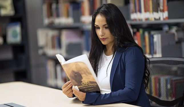 Indigenous woman reading a book.