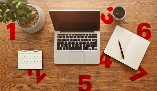 Laptop, notebook, pencil and cup on table