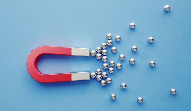 Silver spheres gravitated towards a red magnet on blue background