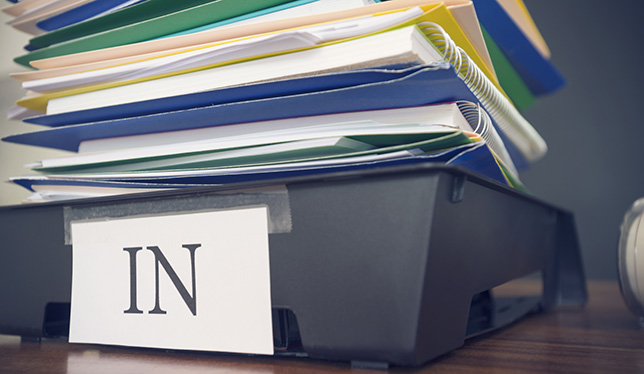 Large stack of paperwork and files with in tray.