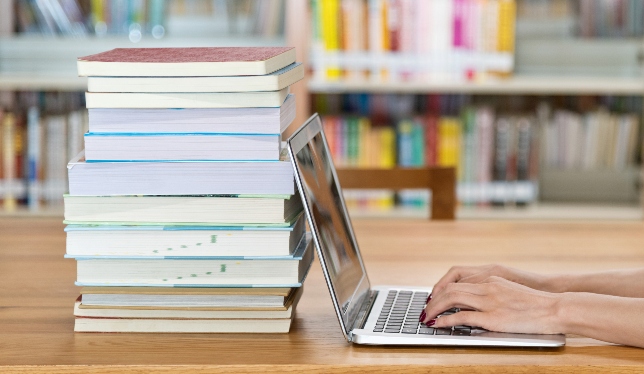 laptop and books on wooden table