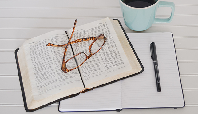 books, pen and green tea on table